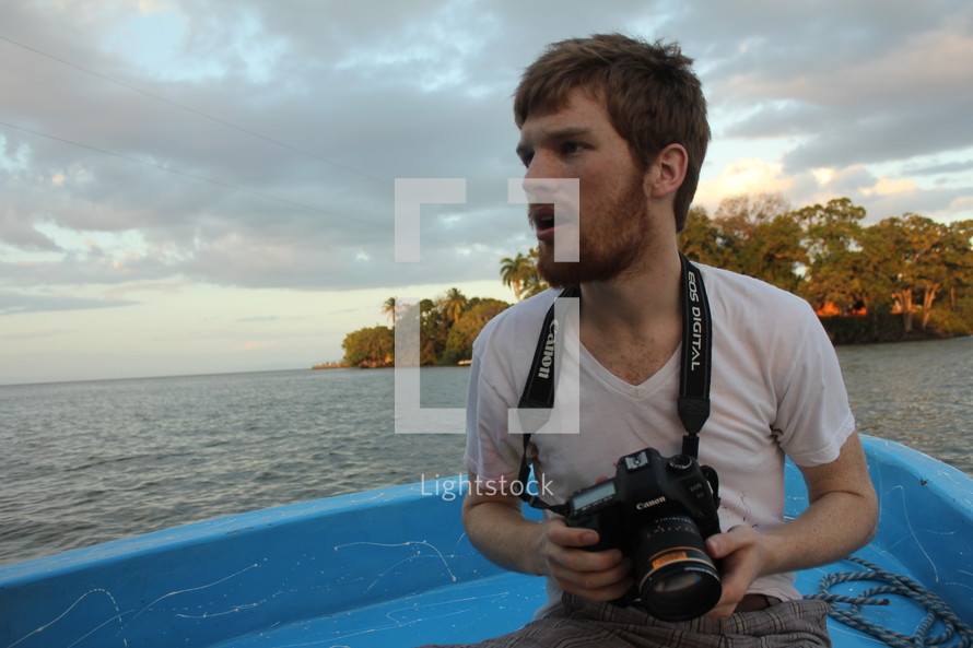 man on a boat holding a camera 