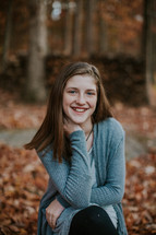 teen girl smiling for a portrait outdoors in fall 