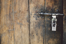 A padlock on an aged wooden door.