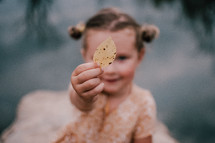 Child holding a fall leaf during autumn