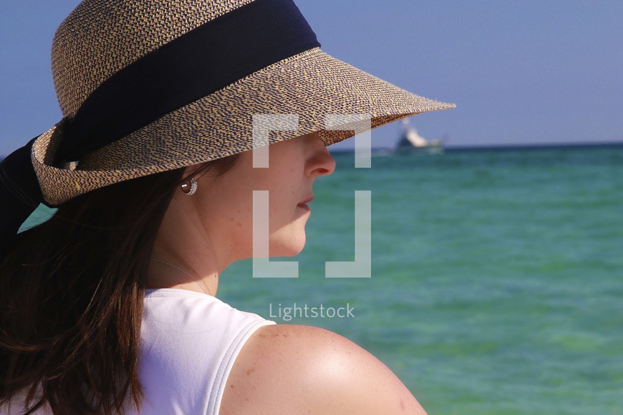 a woman with a sunhat standing outdoors 
