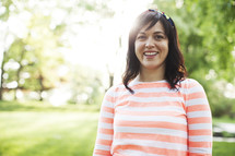 smiling woman standing in a yard.