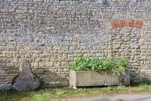 planter box in front of a stone wall 