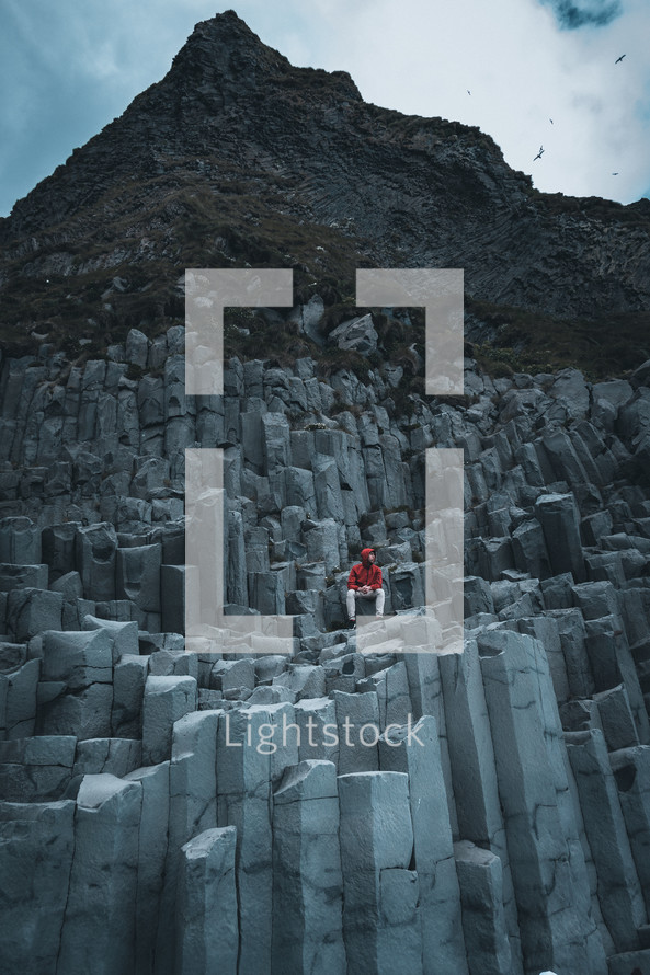 a man sitting on unique rock formations 