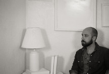 man sitting alone in a white room 
