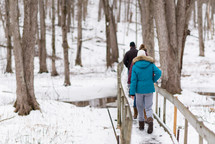 people crossing a winter bridge 