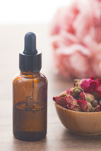 dried roses and essential oil bottle 