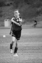 girl running on a soccer field 