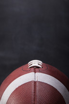 close up of an American football with a chalkboard background. 