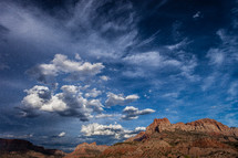 clouds over red rock peaks 