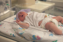 a newborn baby girl in a hospital bed 