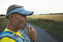 A man drinking water through a hydration vest