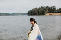 a woman wrapped in a towel after a baptism in a river 