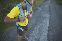 A runner putting on a hydration vest. 