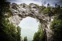 view of ocean water through a rock arch 