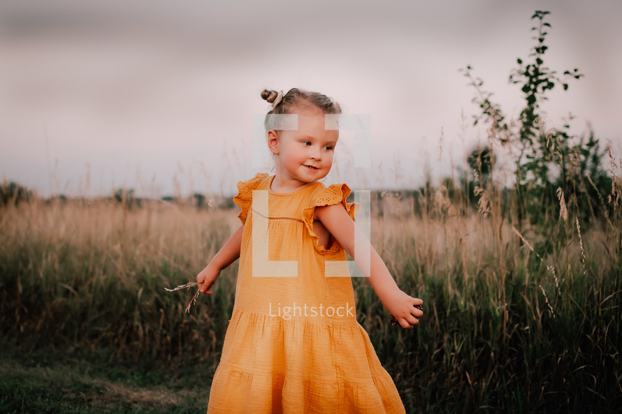 a happy little girl in an orange dress 