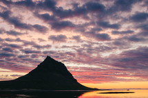 mountain peak along a shoreline at sunset 
