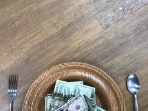offering plate full of money as a place setting 
