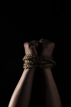 Wrists bound with rope.