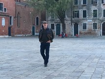 a man walking in an empty courtyard 