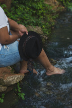a woman sitting with her feet in the water 