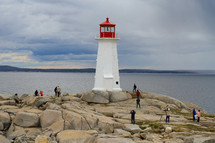 tourists visiting a red and white lighthouse 