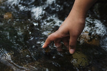 hand reaching into water 