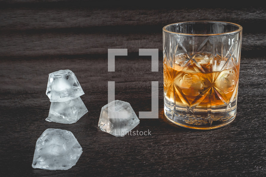 A beautiful glass of wiskey on the Rocks, on a black background. whiskey with ice cubes.