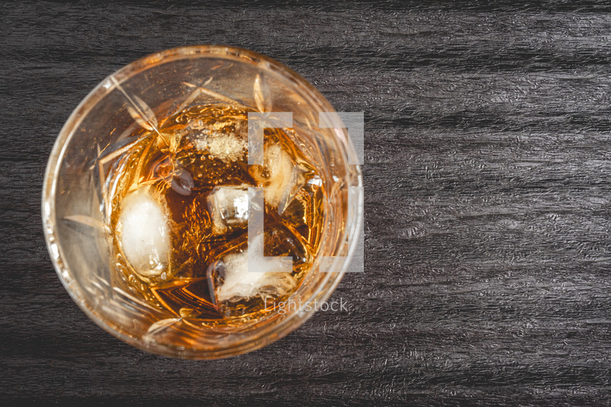 A beautiful glass of wiskey on the Rocks, on a black background. whiskey with ice cubes.