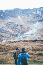 two men hiking a mountain landscape