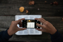 a man taking a picture of Bible scripture with his cellphone 