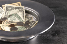 money in a tithing tray 