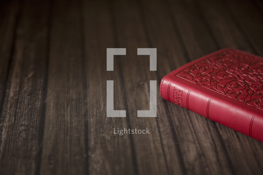 red Bible on wood 