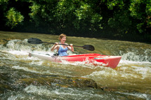 woman kayaking in rapids 