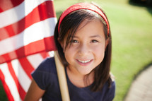 girl child holding an American flag 