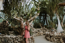 woman walking through an arboretum 
