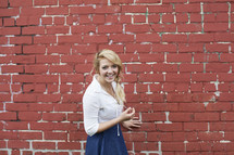 woman smiling and a brick wall 