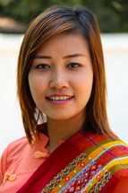 A smiling Asian young woman in traditional Chin clothing 