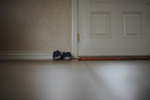 shoes by a door and door mat 