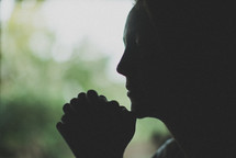 silhouette of a woman in prayer 