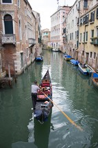 man padding a gondola in Venice 