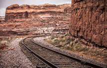 train tracks through red rock cliffs 