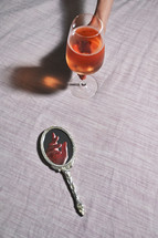 Abstract Hand in Vintage Mirror and Woman hand holding Glass of Rose Wine