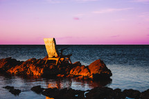 chair on a rock over water 