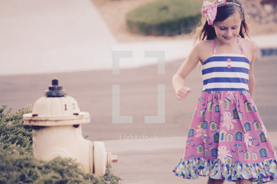 a little girl walking down a sidewalk 