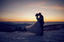 bride and groom at sunset in the snow 