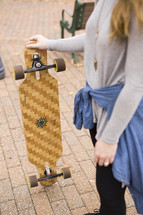a teen girl holding a skateboard 