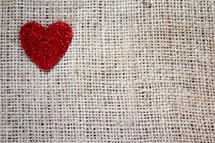 a glittery red heart on burlap 