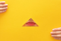 a woman's lips through a yellow piece of paper 