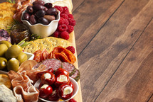 Savory Charcuterie Board Covered in Meats Olives Peppers Berries and Cheese